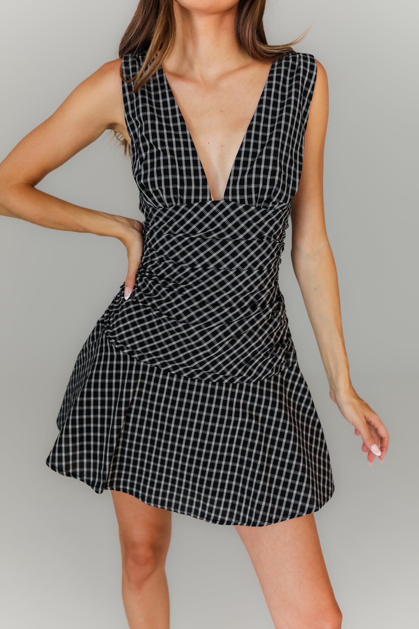 Black and white plaid dress worn by a model on a gray background