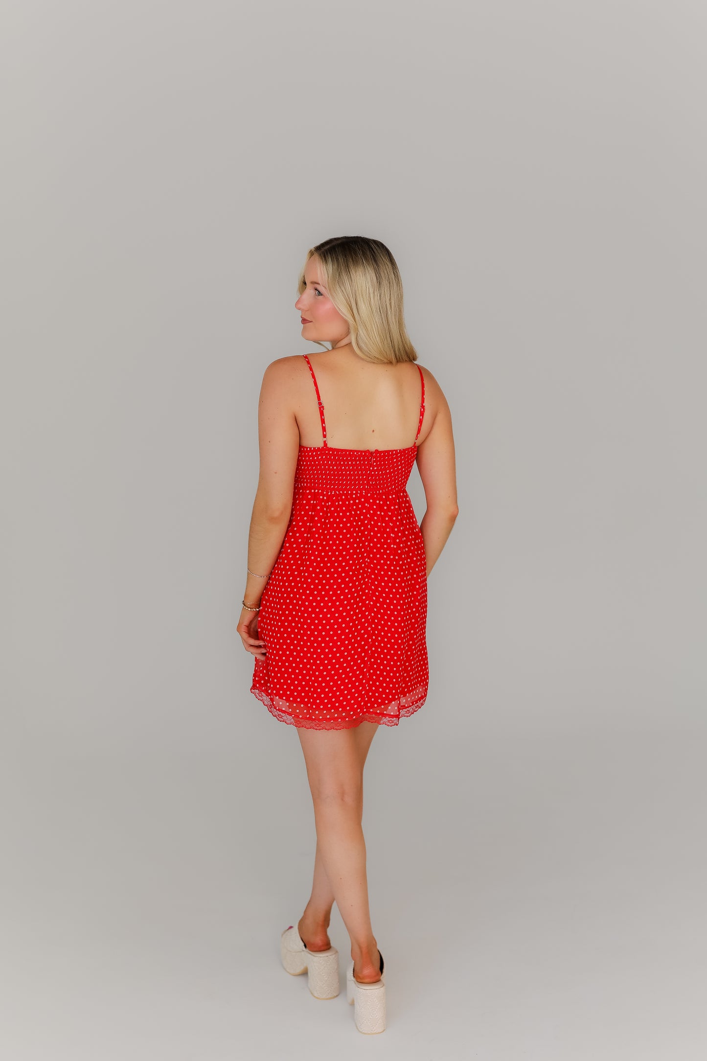 Back of red polka dot mini dress with thin straps boutique style