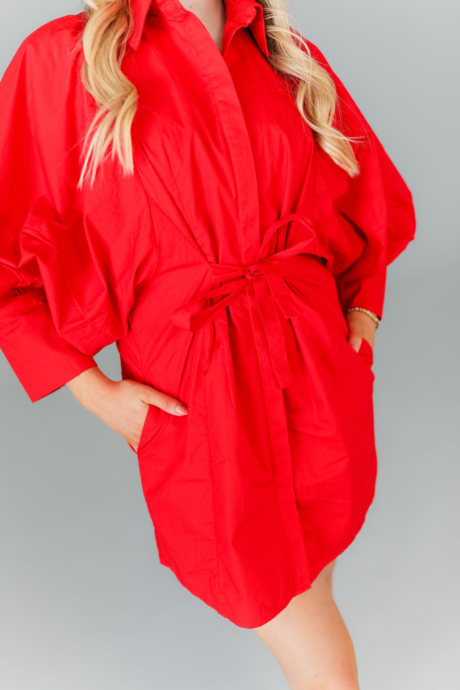 Close-up of red mini dress with balloon sleeves and waist detail