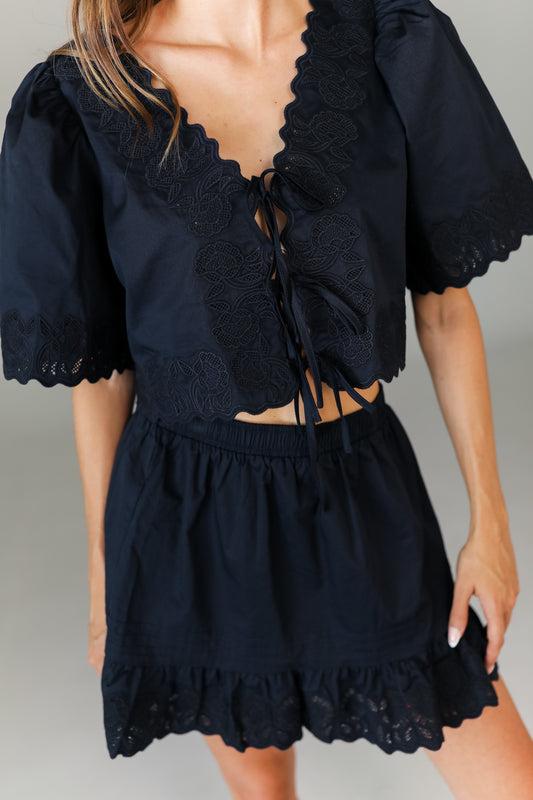 Close-up of navy crop top tie-front paired with mini skirt