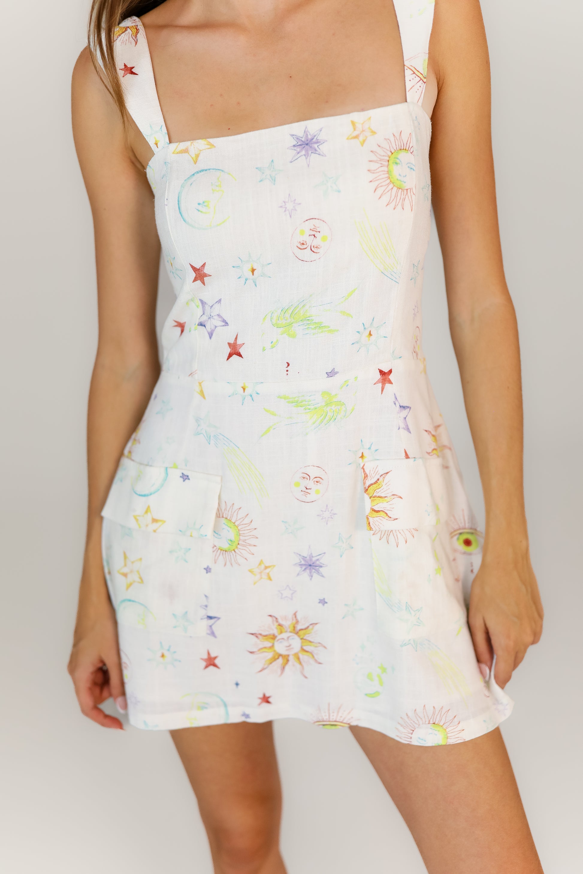 White spaghetti strap mini dress with cosmic pattern & pockets on front