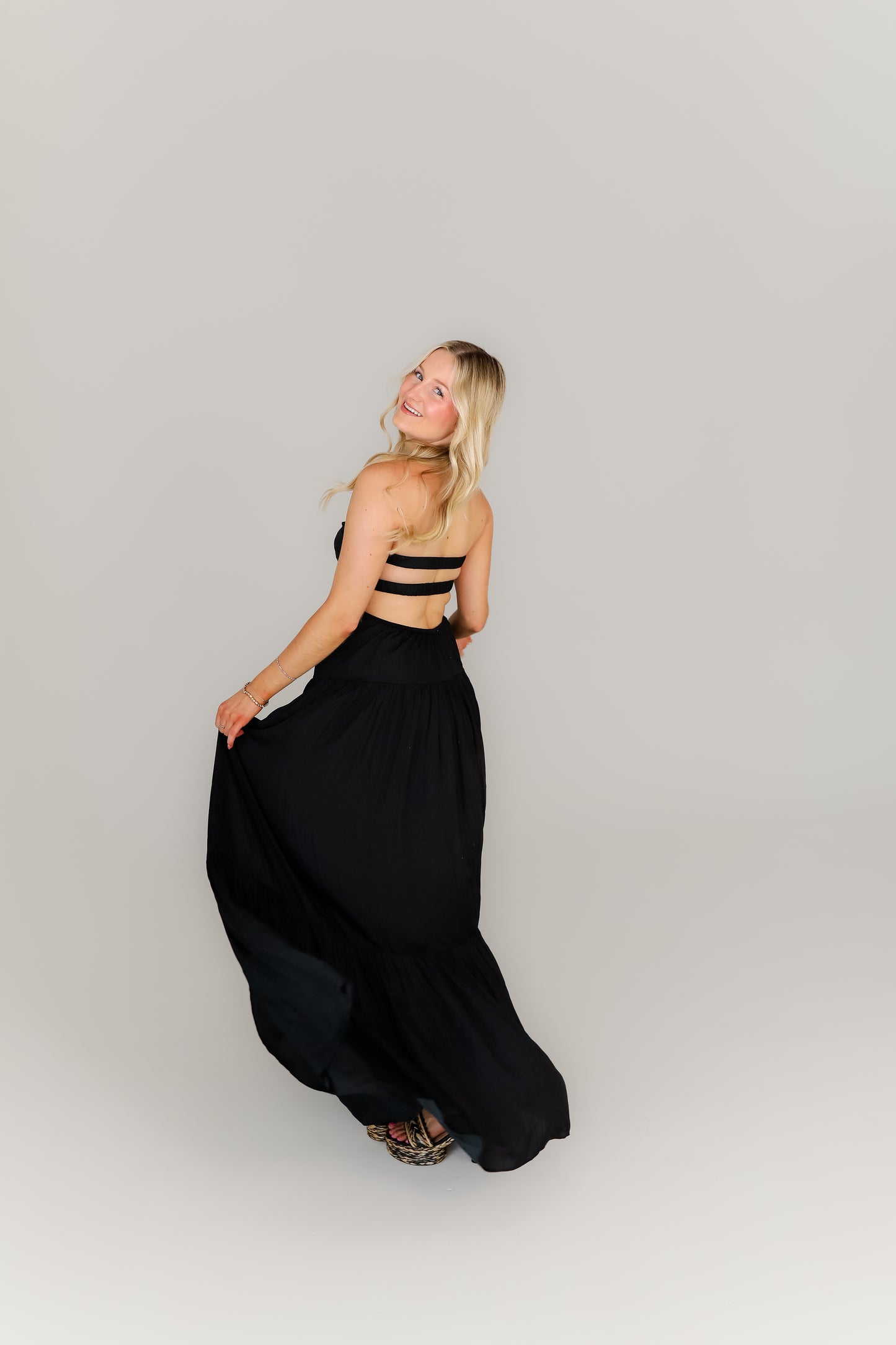 Strappy black dress with a sweetheart neckline styled with heels