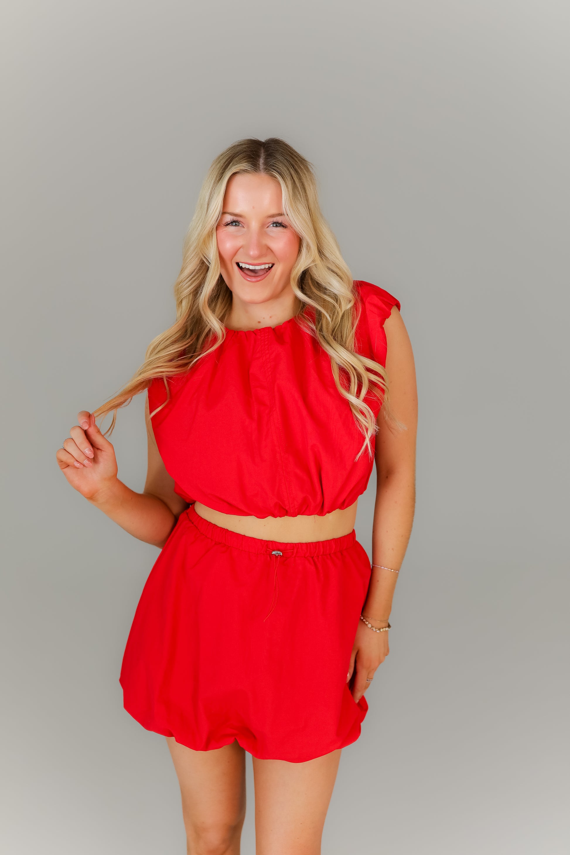 Model wearing red bubble set with sleeveless top and skirt