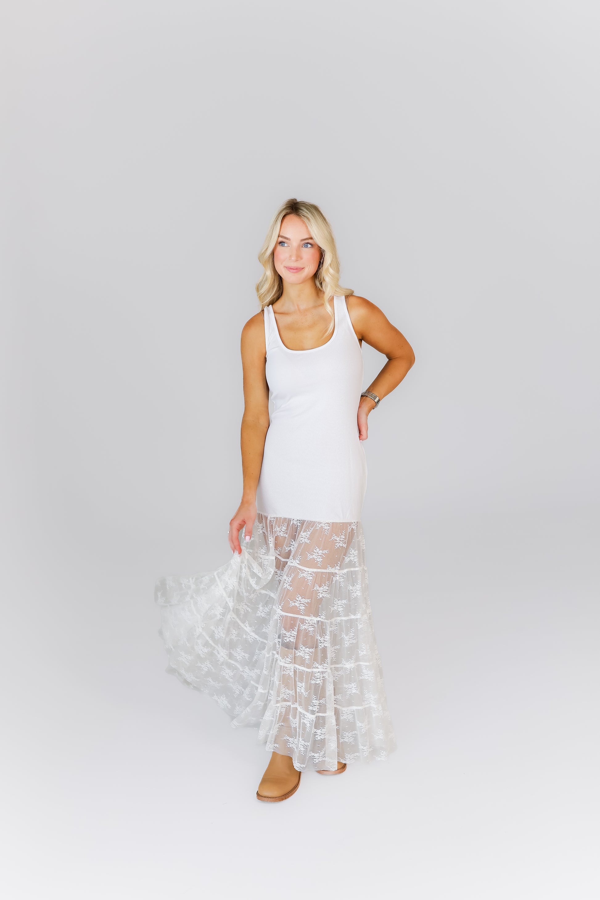 Model wearing white maxi dress with lace tiered skirt and tank top bodice