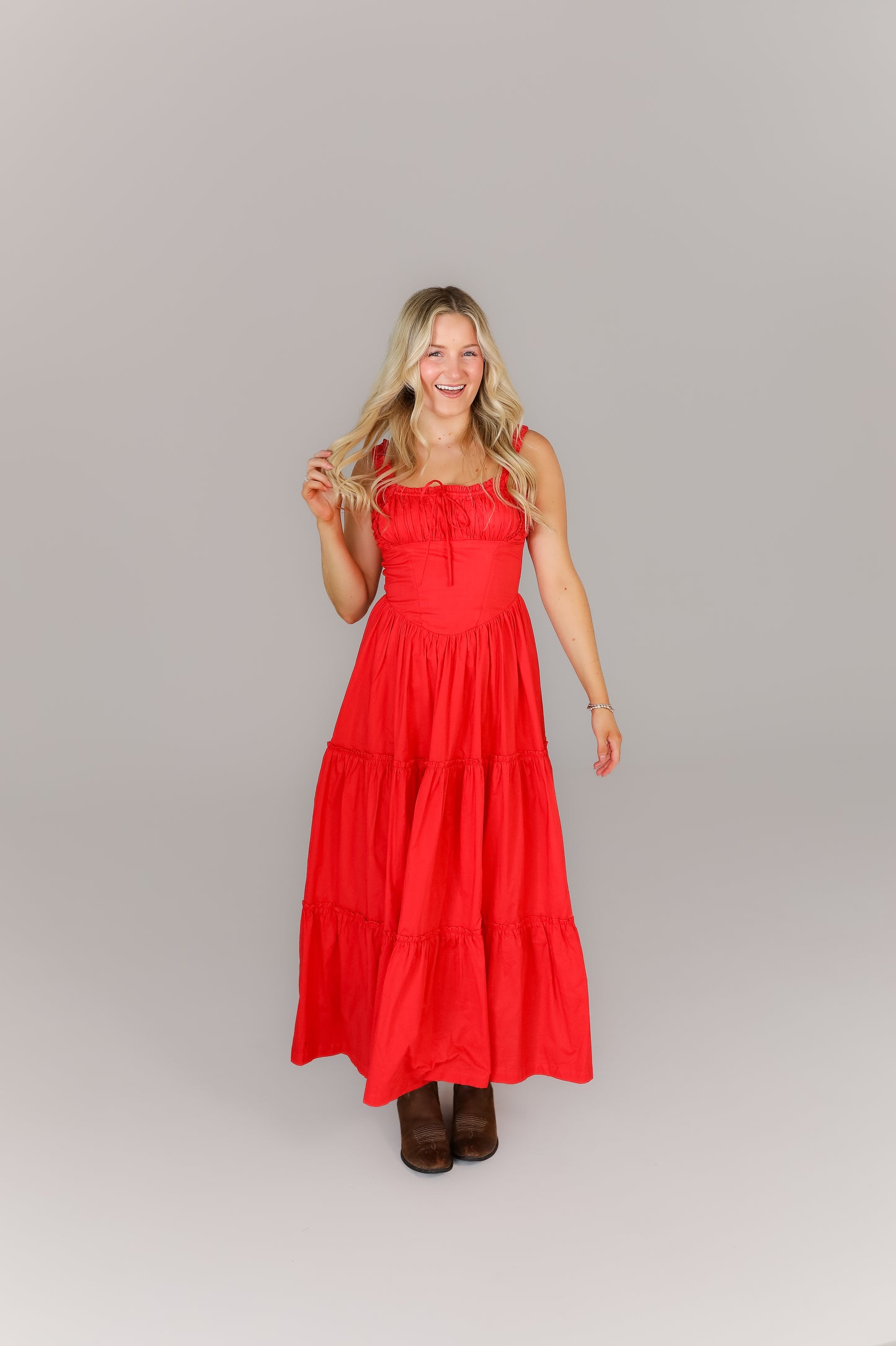 Woman in bright red sleeveless midi dress with flowy hemline