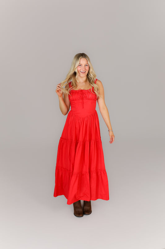 Woman in bright red sleeveless midi dress with flowy hemline