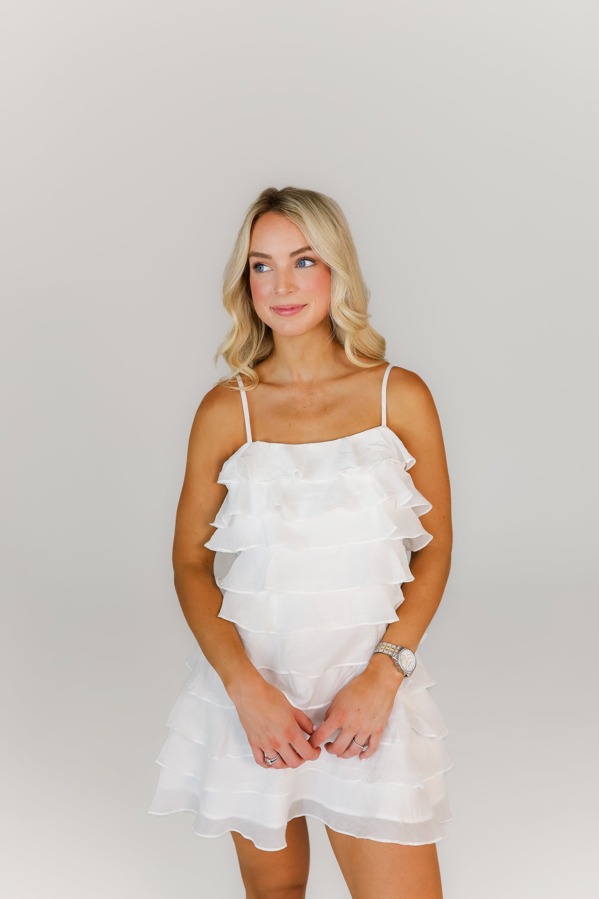 Model posing in chic white boutique mini dress