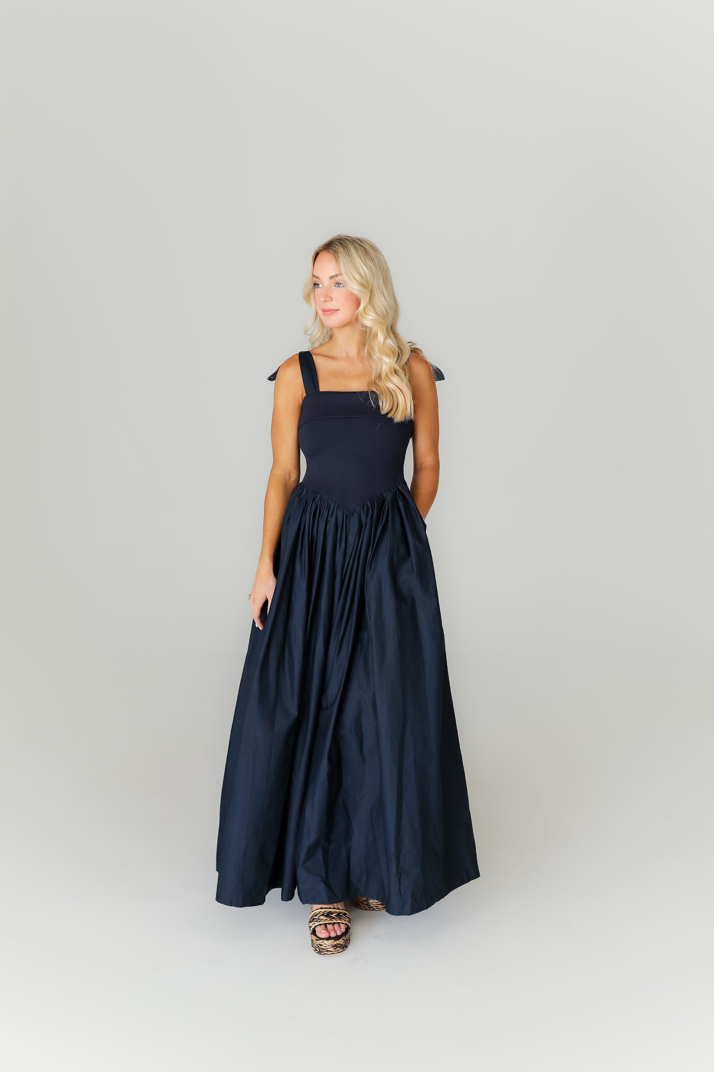 Woman wearing a navy blue dress against a white background