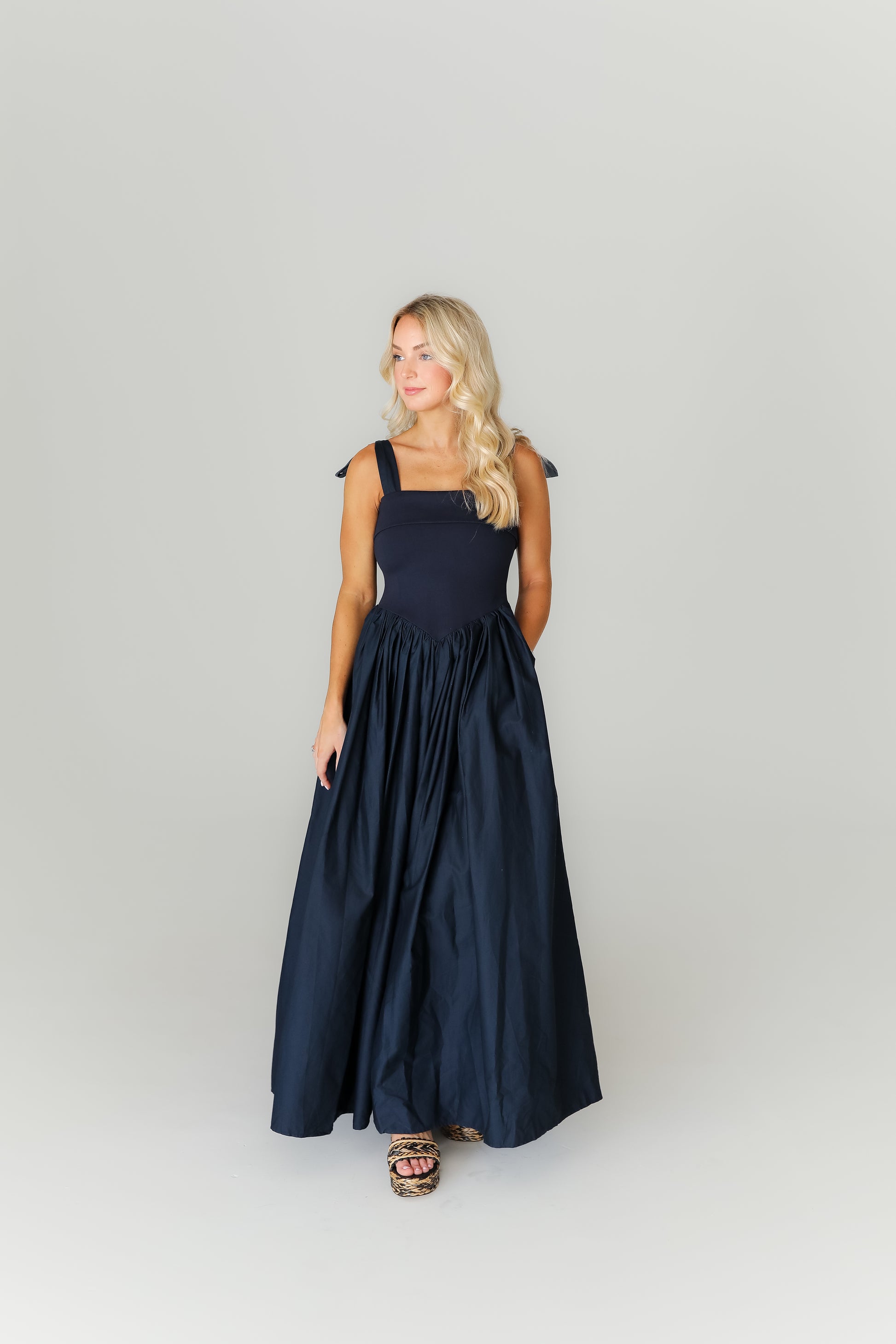 Woman wearing a navy blue dress against a white background