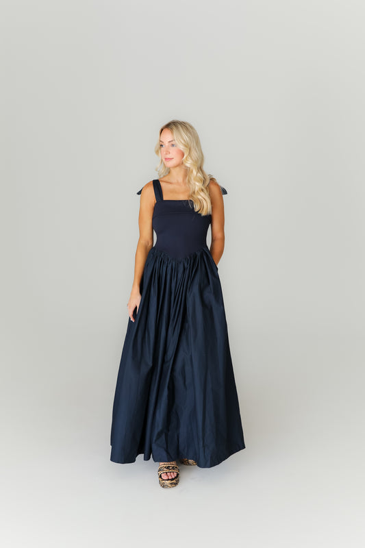 Woman wearing a navy blue dress against a white background