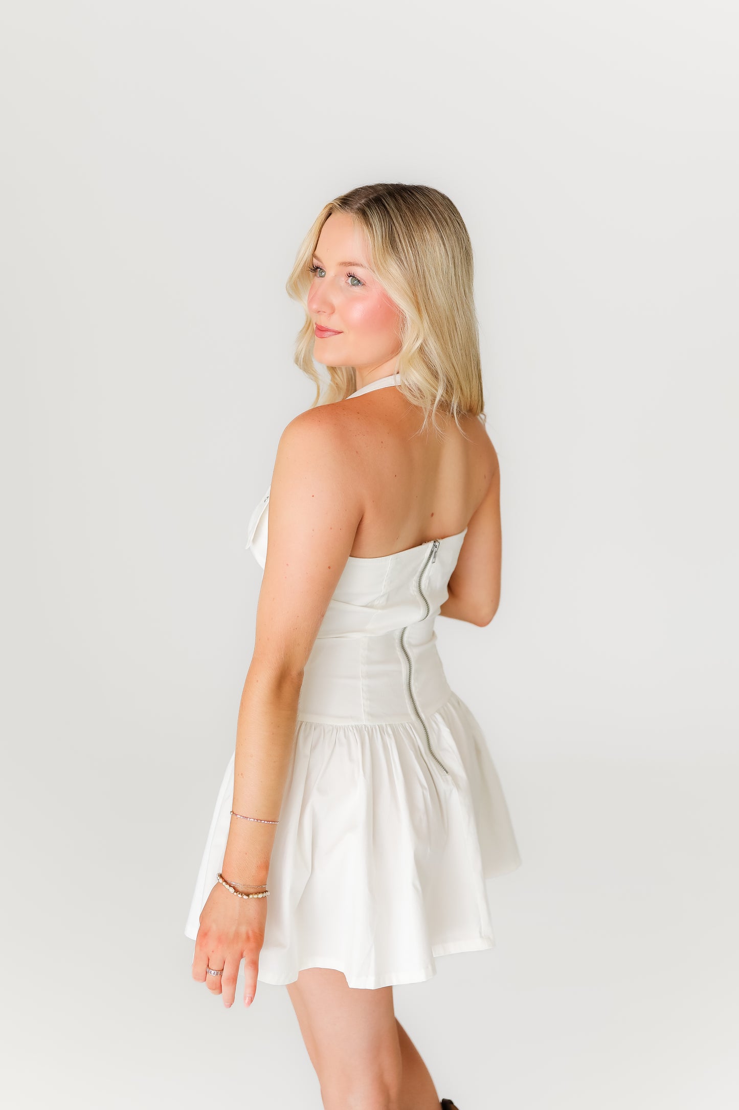 Woman wearing a white dress against a plain background