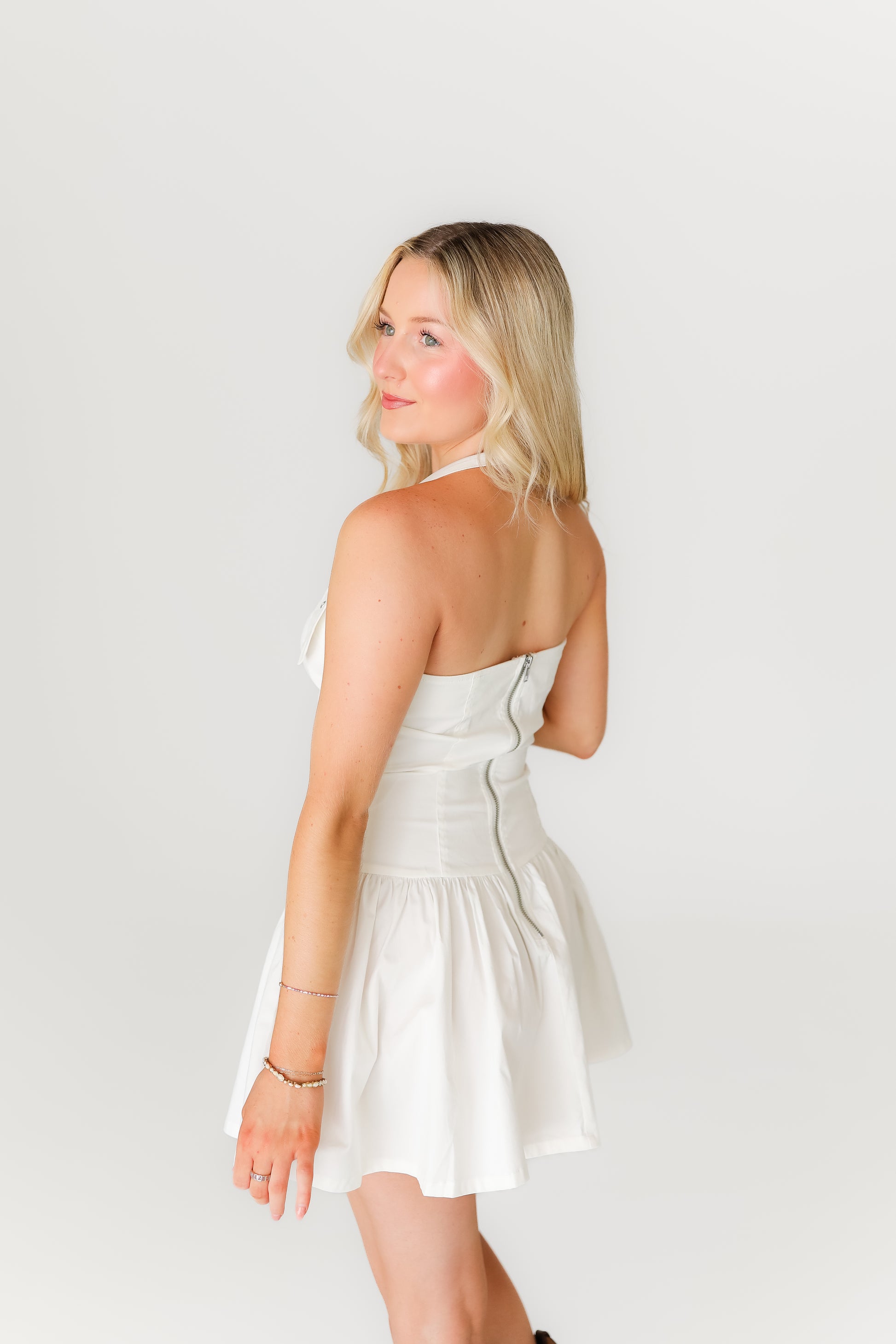 Woman wearing a white dress against a plain background