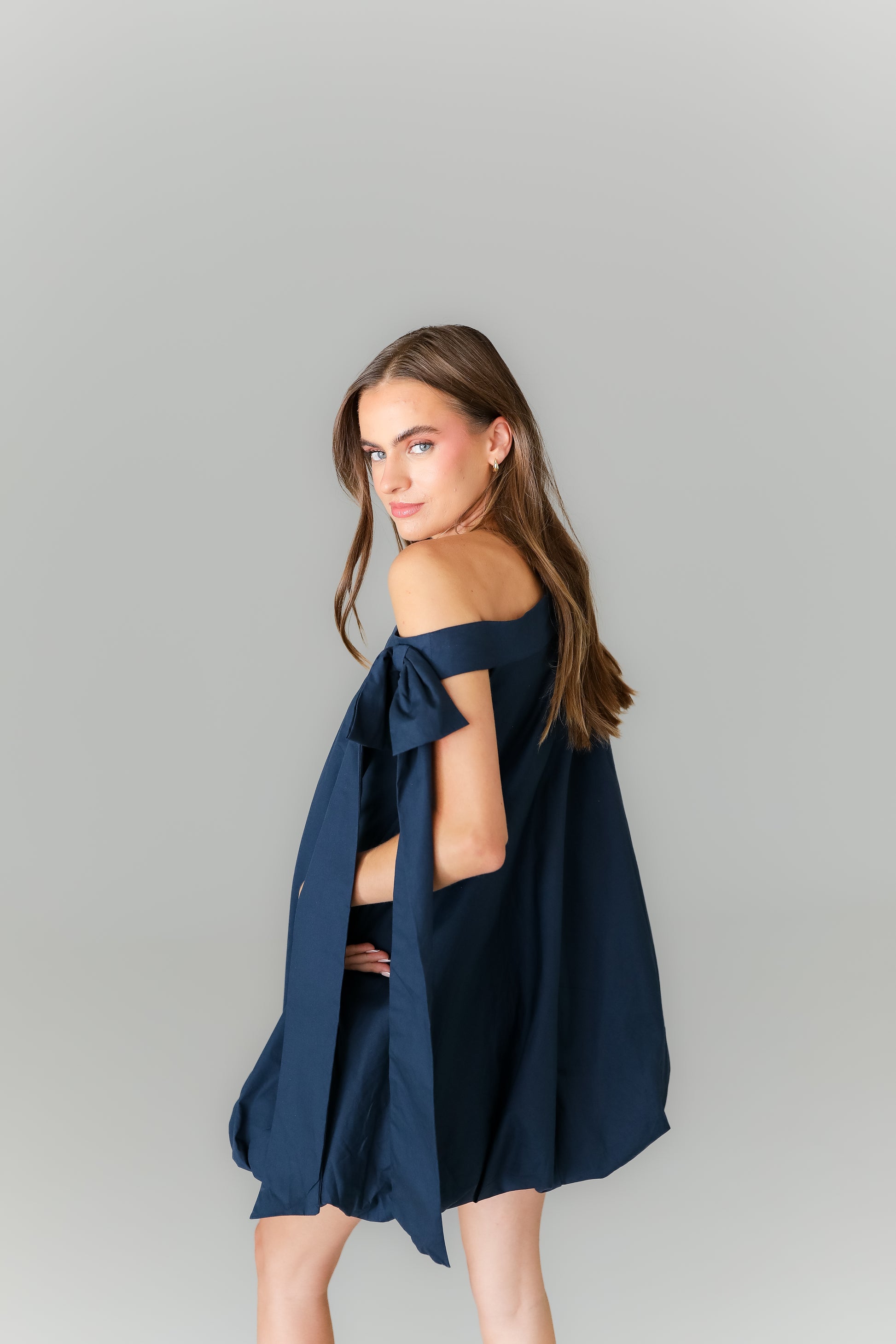 Back view of navy blue mini dress with flowy bubble silhouette